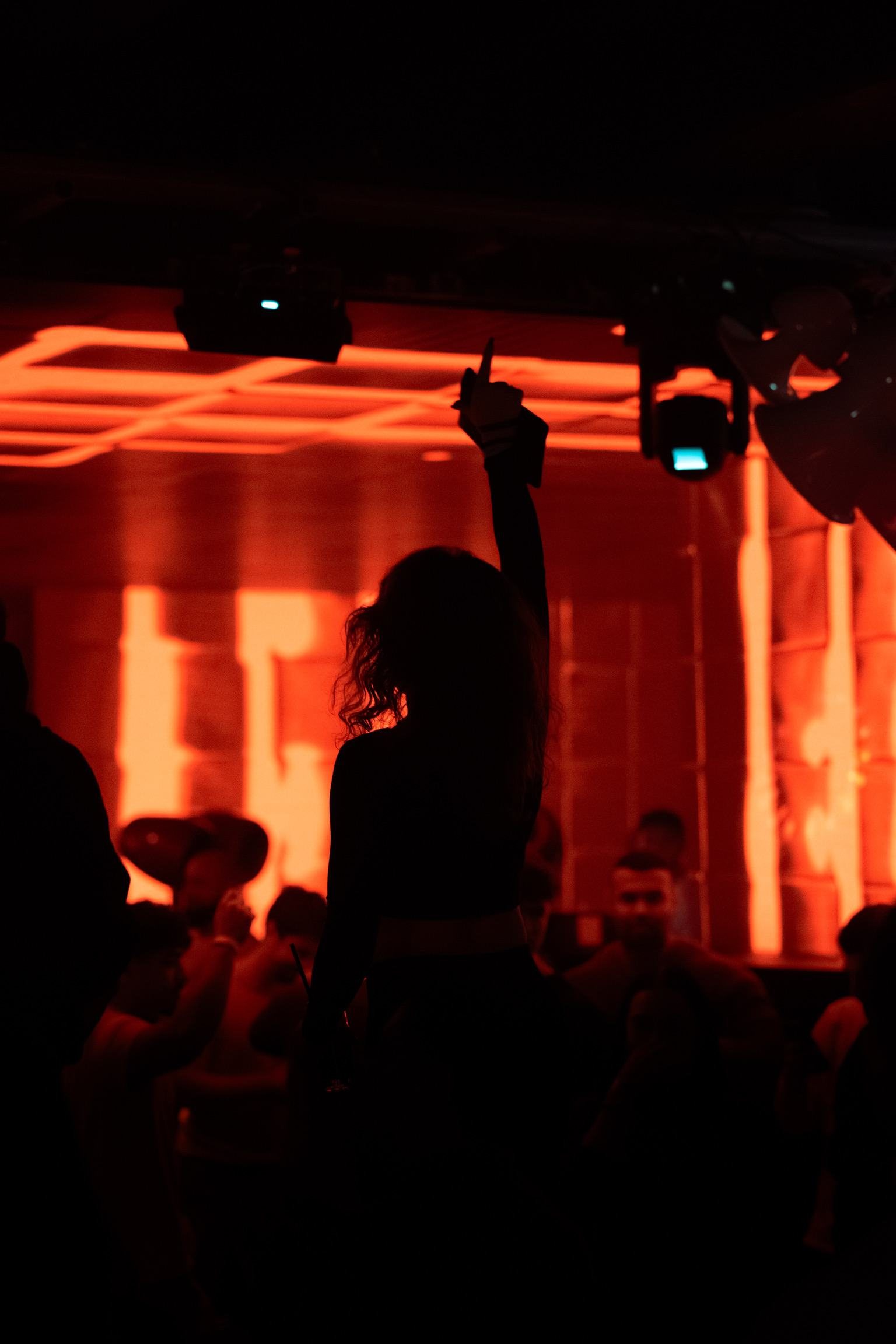 Tanzende Menschen im Club bei rotem Licht